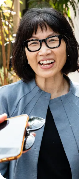 Symposium attendee smiling while holding a phone