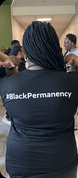 BEC community member wearing a #BlackPermanency shirt at a gathering