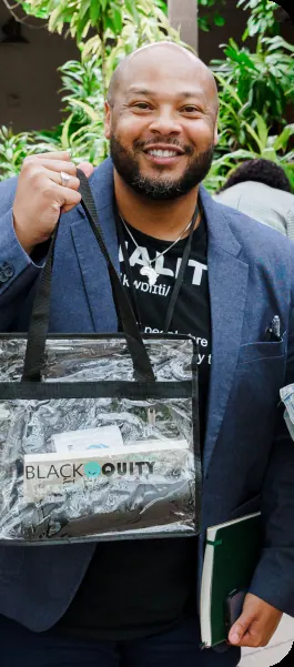 BEC attendee holding a Black Equity Collective gift bag at an event